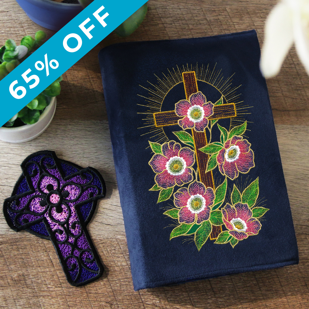 Spring Style - 65% off - Image Features: a Bible cover stitched with a cross surrounded by Lenten roses. There is a freestanding lace cross to the left of the Bible. Click here to shop.