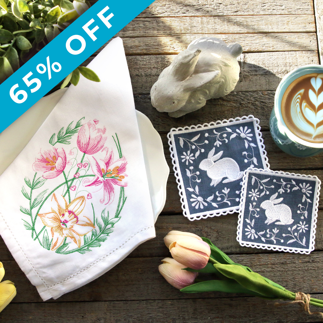 Spring Has Sprung - Image Features: a tea towel stitched with an egg made of tulips and daffodils. There are bunny coasters with a freestanding lace edge. Scene is an Easter brunch table setting - click here to shop.
